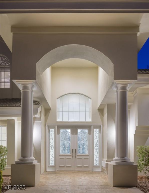 entrance foyer featuring a wealth of natural light, french doors, and a towering ceiling