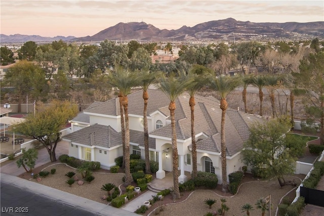 aerial view at dusk featuring a mountain view