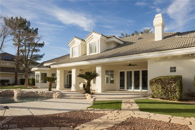 back of house with ceiling fan and a patio