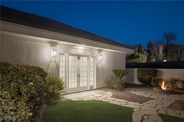 exterior space featuring french doors, a fire pit, and a patio area