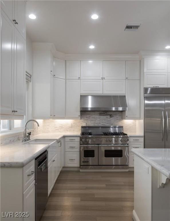 kitchen with range hood, white cabinets, sink, and appliances with stainless steel finishes