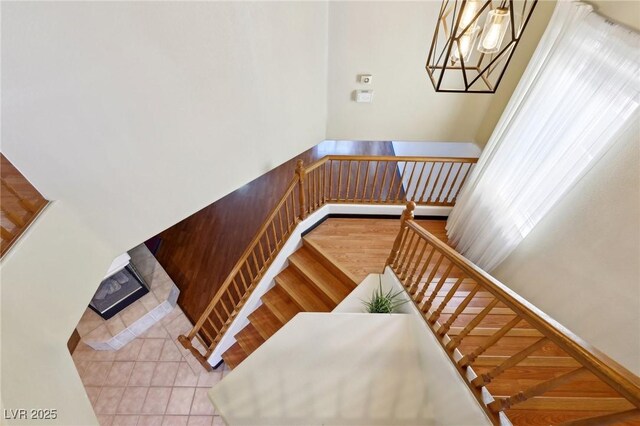 stairway featuring a tile fireplace and tile patterned floors