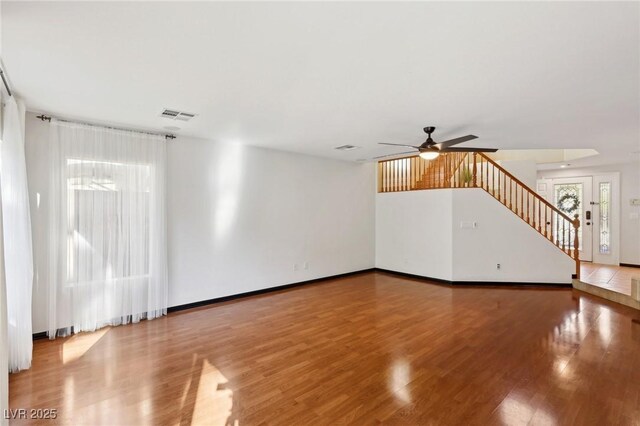 unfurnished living room with ceiling fan and hardwood / wood-style floors