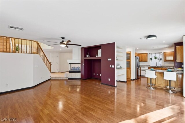 unfurnished living room with ceiling fan and light hardwood / wood-style floors