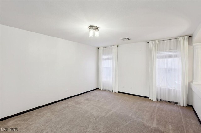 empty room with radiator, light carpet, and a healthy amount of sunlight