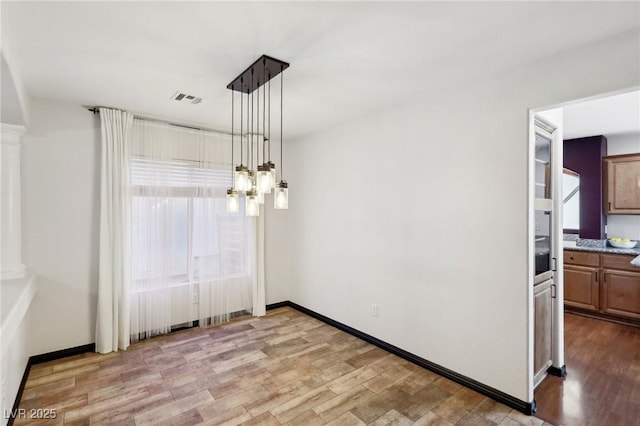 unfurnished dining area featuring light wood-type flooring