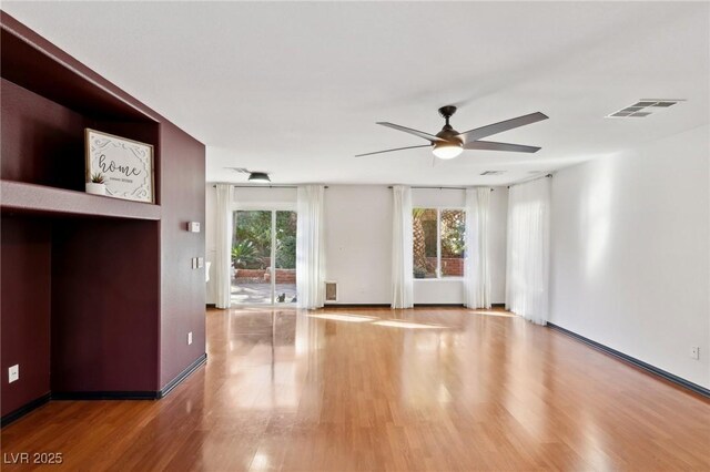 empty room with hardwood / wood-style floors and ceiling fan