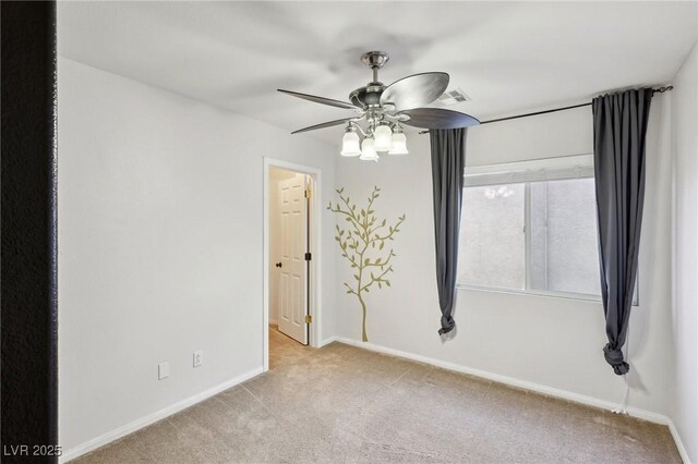 spare room with ceiling fan and light carpet