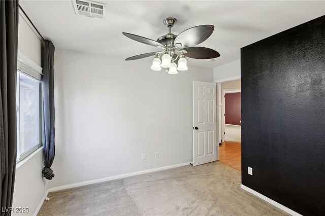 carpeted empty room featuring ceiling fan and plenty of natural light