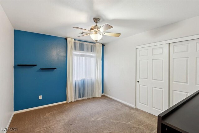 unfurnished bedroom featuring ceiling fan, a closet, and carpet flooring