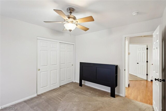 bedroom featuring ceiling fan, a closet, and light carpet