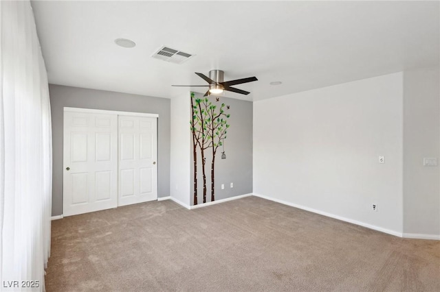 unfurnished bedroom with a closet, ceiling fan, and light carpet