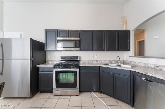 kitchen with stainless steel appliances, light tile patterned floors, and sink