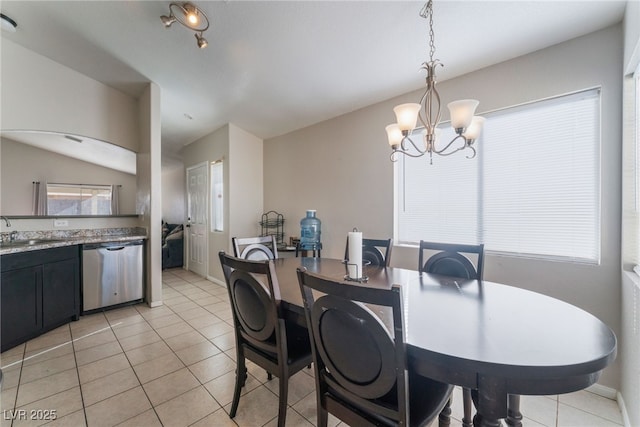 tiled dining room with sink and a chandelier