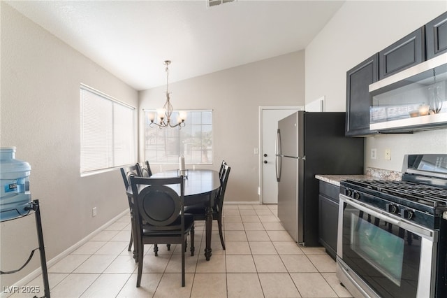 kitchen with an inviting chandelier, appliances with stainless steel finishes, lofted ceiling, decorative light fixtures, and light tile patterned flooring