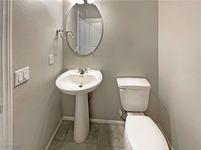 bathroom with toilet and tile patterned flooring