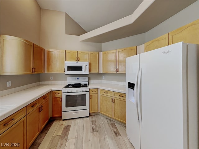 kitchen featuring white appliances, light wood-type flooring, tile counters, and light brown cabinets