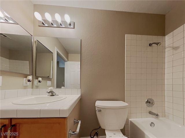 full bathroom with toilet, tiled shower / bath, and vanity