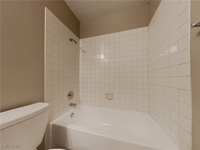 bathroom featuring tiled shower / bath and toilet