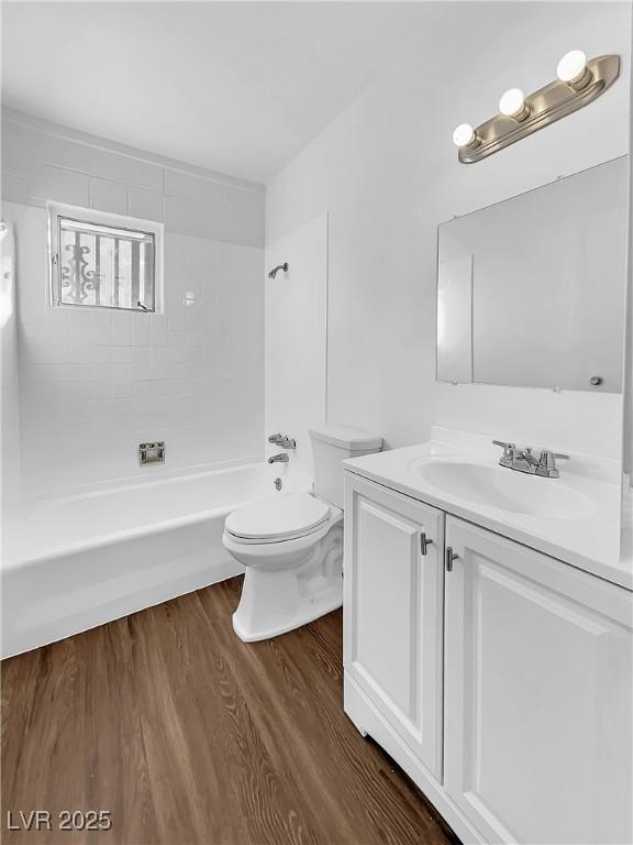 full bathroom featuring bathing tub / shower combination, hardwood / wood-style floors, vanity, and toilet