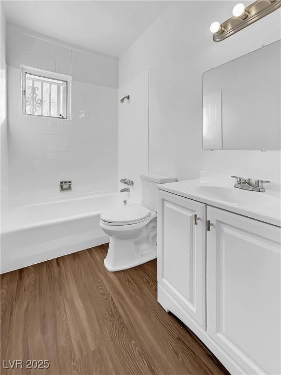 full bathroom with toilet,  shower combination, vanity, and hardwood / wood-style flooring