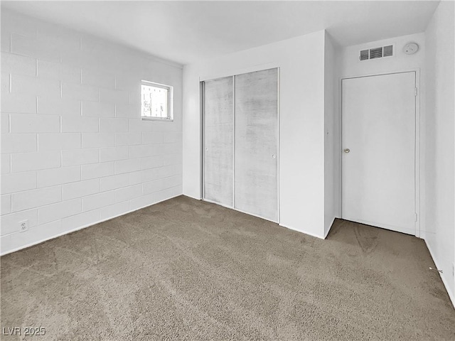 unfurnished bedroom featuring a closet and dark carpet