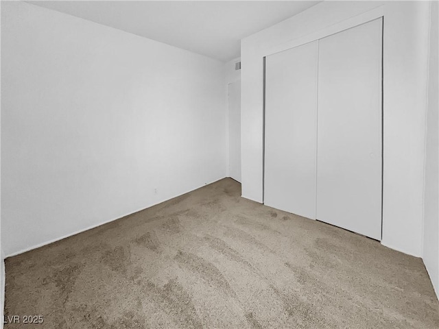 unfurnished bedroom with a closet and carpet flooring