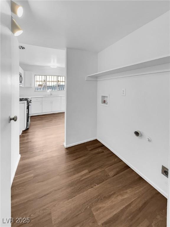 washroom with sink, hookup for a washing machine, and dark wood-type flooring