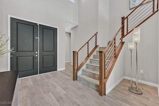 entrance foyer with a high ceiling and light wood-type flooring