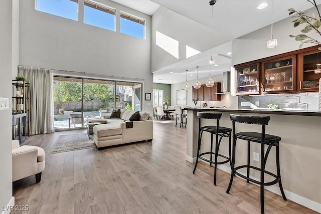 living room featuring a towering ceiling and light wood-type flooring