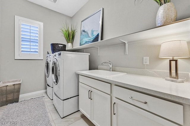 laundry area with sink, washer and clothes dryer, and cabinets