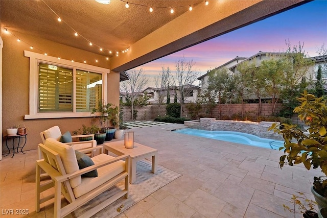 pool at dusk featuring a jacuzzi, a patio, and pool water feature