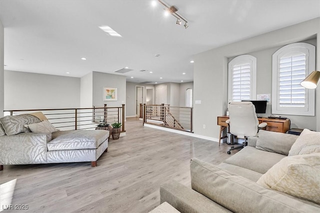 living room featuring light wood-type flooring and rail lighting