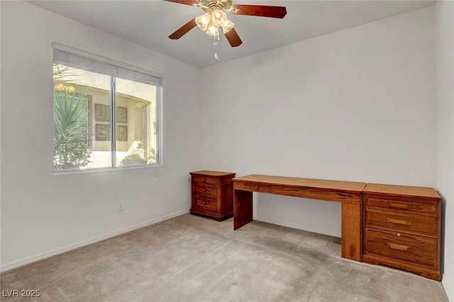 unfurnished office with ceiling fan and light carpet