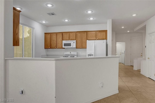 kitchen with white appliances, kitchen peninsula, and light tile patterned floors