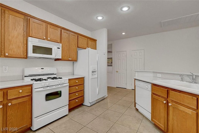 kitchen featuring white appliances, sink, and light tile patterned floors