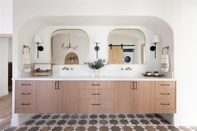 full bathroom featuring double vanity, stacked washer / drying machine, and a sink