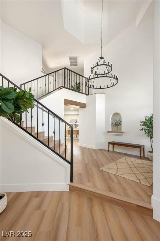 stairway featuring a high ceiling and a chandelier