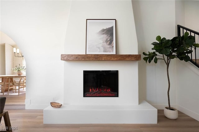 interior details featuring a glass covered fireplace and wood finished floors