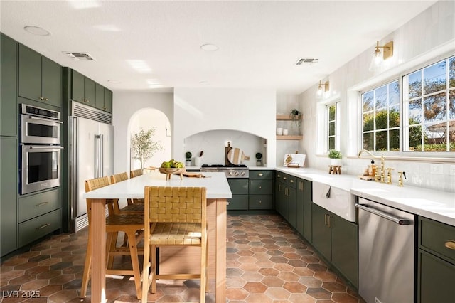 kitchen featuring visible vents, appliances with stainless steel finishes, green cabinets, and light countertops