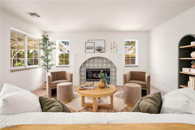 living room featuring a fireplace, a wealth of natural light, and light wood-type flooring