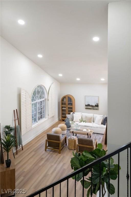 living area with recessed lighting, baseboards, and wood finished floors