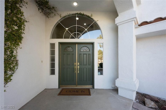 doorway to property featuring stucco siding