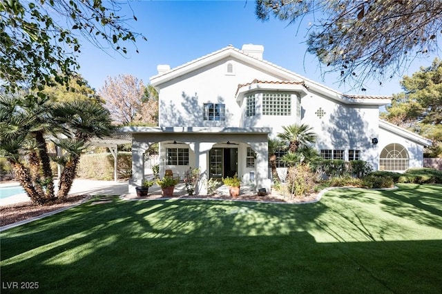 view of front of property with stucco siding, a front lawn, a pergola, a patio, and a chimney