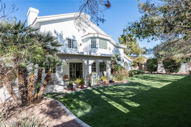 rear view of property with a yard and a patio