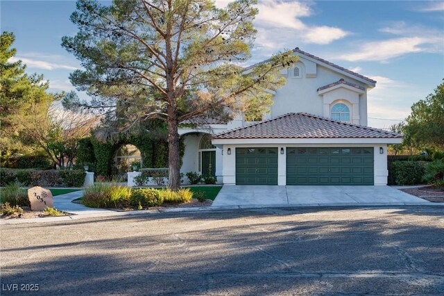 view of front of house featuring a tiled roof, stucco siding, driveway, and a garage