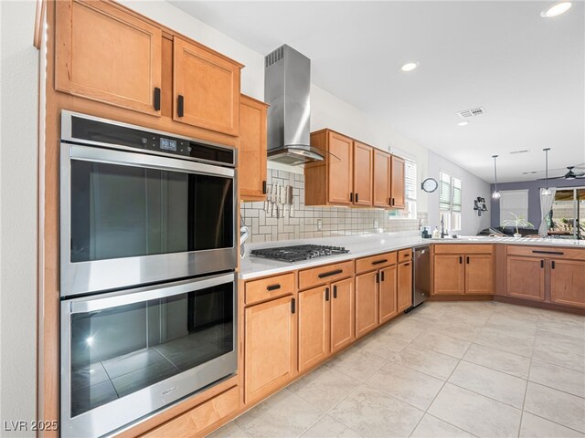 kitchen with appliances with stainless steel finishes, hanging light fixtures, light tile patterned floors, range hood, and tasteful backsplash