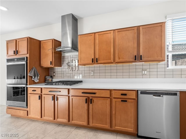 kitchen featuring light tile patterned flooring, appliances with stainless steel finishes, wall chimney range hood, and decorative backsplash