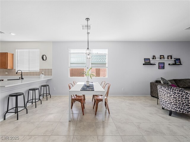 dining space featuring sink and light tile patterned floors