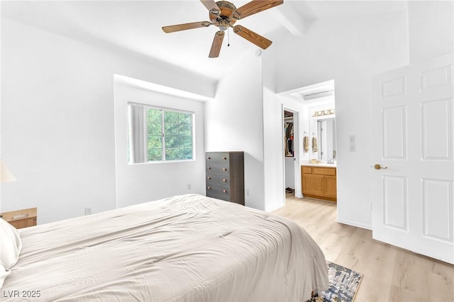 bedroom with ceiling fan, ensuite bath, light wood-type flooring, and vaulted ceiling with beams